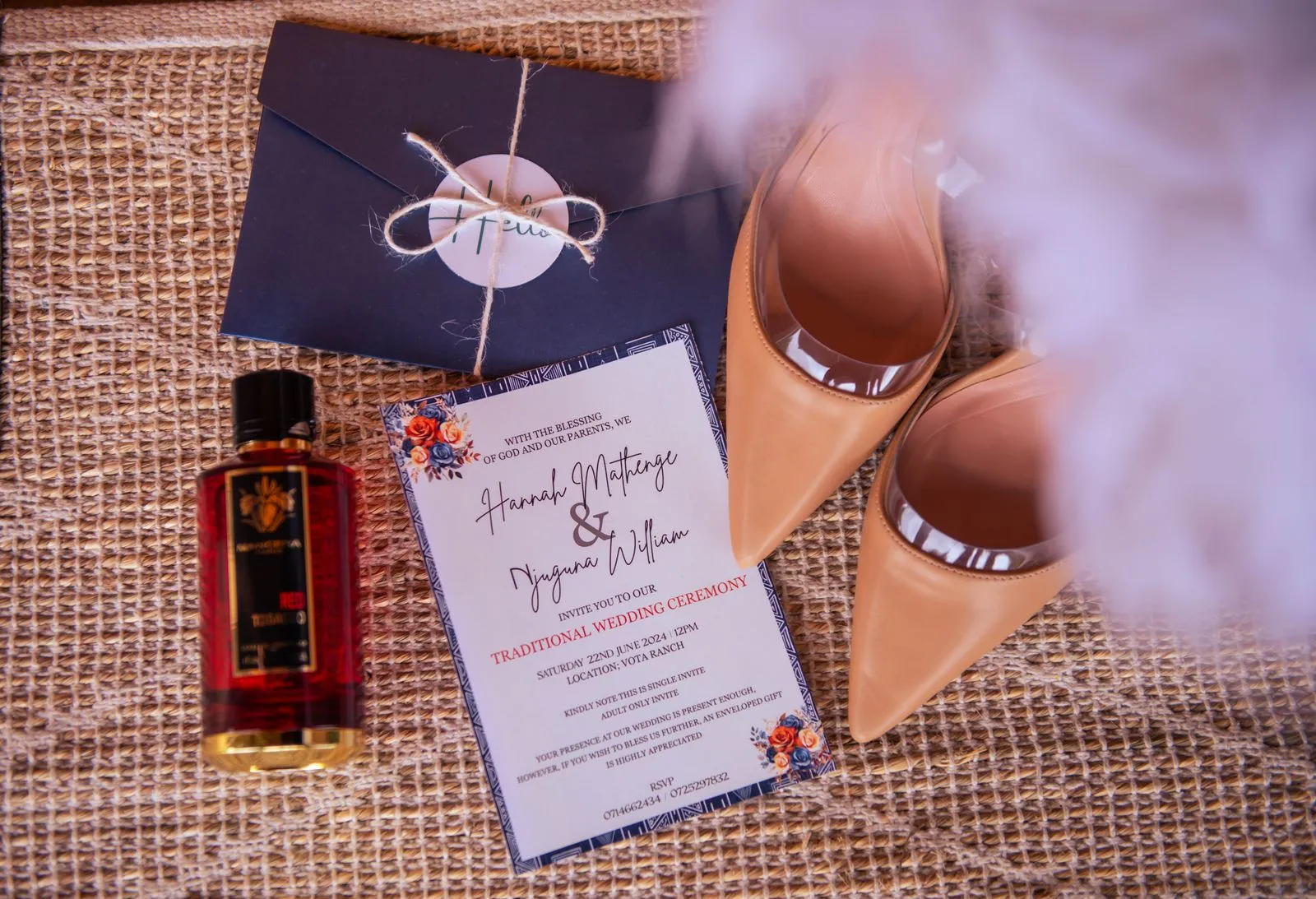 Stylish flat lay of wedding invitation, heels, envelope, and perfume bottle on textured surface.